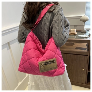 Détail du sac cabas matelassé rose avec coutures en losange et large bandoulière