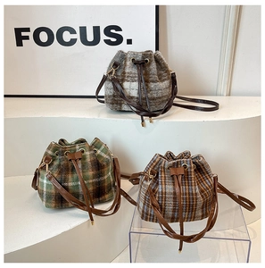 Dettaglio di tre borse a secchiello in tweed a quadri grigi, verdi e blu con coulisse