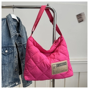 Détail du sac cabas matelassé rose vif avec large bandoulière et étiquette en tissu