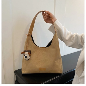 Détail du cabas en daim kaki avec bandoulière en cuir et pendentif chien mignon