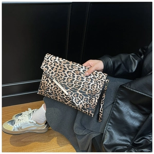 Dettaglio della pochette leopardata con bordo in metallo indossata da una modella in studio