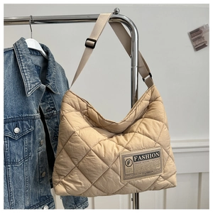 Détail du sac cabas matelassé beige avec étiquette mode et bandoulière réglable