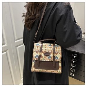 Close-up of retro jacquard crossbody bag with diamond pattern and brown leather handle