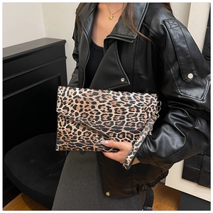 Dettaglio della pochette leopardata con bordo in metallo dorato e cinturino da polso