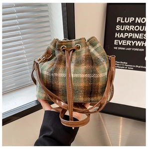 Detalle del bolso de cuadros con tejido de lana, cordón de cuero y hebilla dorada