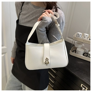 Close-up of white shoulder bag with distinctive golden gourd-shaped buckle on model