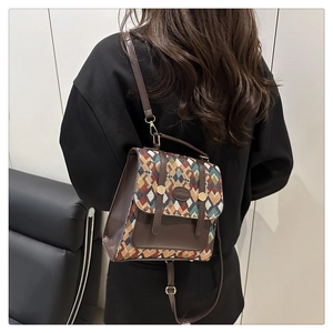 Detailed view of vintage-style multi-color woven backpack with brown leather accents