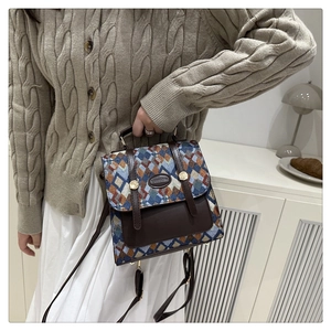 Detailed view of vintage quilted fabric texture and brown leather strap on backpack