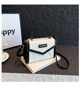Detail of contrast stitching and woven texture on a stylish black and white handbag