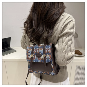 Detail of vintage geometric jacquard backpack with leather flap and top handle on model