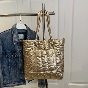 Golden quilted puffer tote bag with large front pocket and long shoulder straps