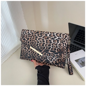 Elegante pochette a busta leopardata con cinturino da polso in un ambiente moderno