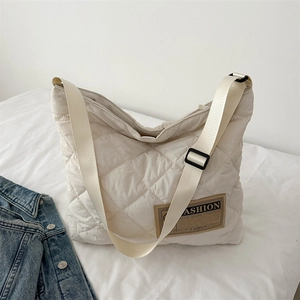 Beige quilted tote bag with large diamond stitching and adjustable shoulder strap for work