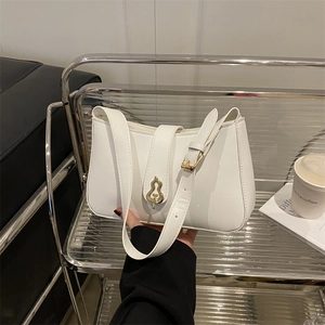 Elegant white leather baguette bag with a unique gold-tone gourd-shaped metal clasp
