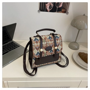 Detail of vintage geometric woven backpack on a desk with a laptop and croissant