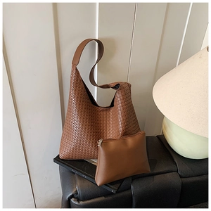 Detail of caramel brown woven hobo bag and matching smooth leather zipper pouch set