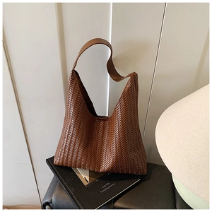 Detail of woven texture on caramel brown leather shoulder bag for commuting