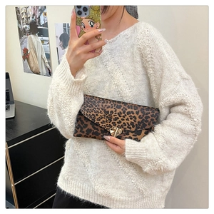Detail view of leopard print envelope clutch with gold triangle metal buckle accent