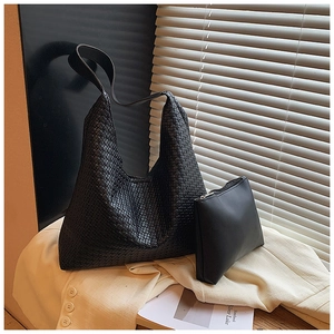 Close-up of woven shoulder bag and matching pouch on a blazer with artistic lighting