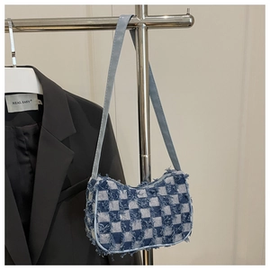 Détail du sac en jean à damier bleu et blanc avec bords effilochés et bandoulière