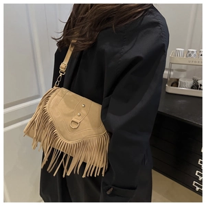 Detail of khaki frosted suede saddle bag with metal rivets and long tassels on coat
