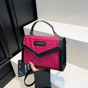 Rose red woven crossbody bag with black handles and fashion tag on minimalist background