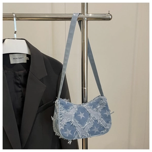Détail du sac à bandoulière en denim bleu clair avec motif étoile aux bords effilochés