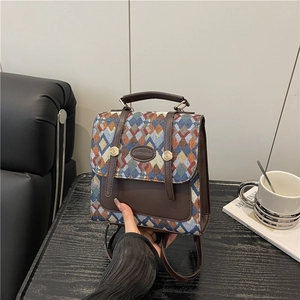 Mini multi-color geometric woven backpack with dark brown leather trim and top handle