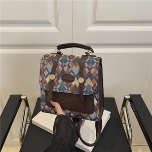 Bohemian geometric woven mini backpack with brown leather trim and metal accents