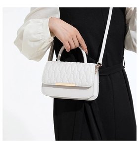 Bolso bandolera blanco acolchado con detalles dorados lucido por una modelo real