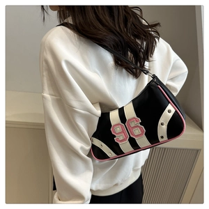 Detailed back view of a black leather underarm bag with pink trim and number 96 patch