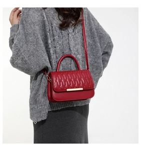 Bolso bandolera rojo acolchado con patrones de corazones y detalles de metal dorado
