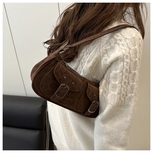 Brown suede underarm bag with vintage metal buckles and dual pockets shown on a model