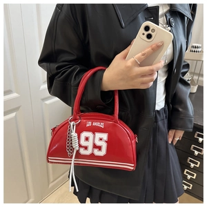 Detail of red patent leather crescent bag with white sporty graphics and silver chain