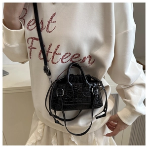 Detail view of black crocodile pattern bucket bag with silver hardware and drawstring