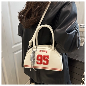 Detail of white crescent bag with red Los Angeles 95 print and silver chain charm