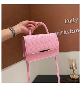 Detalle de textura de cuadros rosa y barra dorada en el bolso de hombro elegante