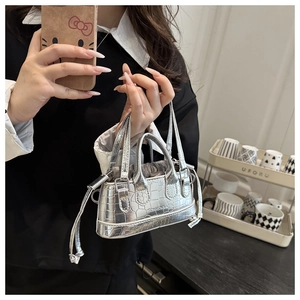Silver mini handbag with crocodile pattern texture and metallic finish shown in hand