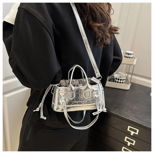 Detail of silver crocodile-textured mini bag with drawstring lining and metal finish