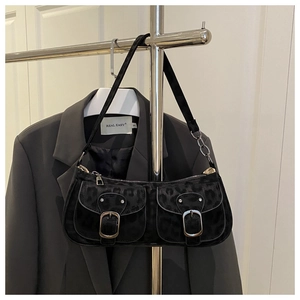 Close-up of black leopard print shoulder bag with dual front pockets and silver buckles