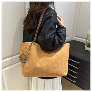 Detail of camel suede tote bag with dark brown straps and ring buckle accessory