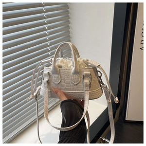 Détail d'un mini sac blanc à motif crocodile avec pochette intérieure à cordon