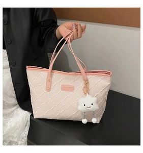 Detail of pink quilted tote bag with texture fabric and cute cloud plush charm