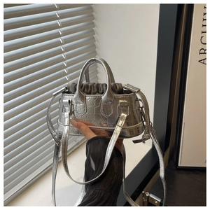 Détail du mini sac à main argenté motif crocodile avec pochette intérieure et sangle