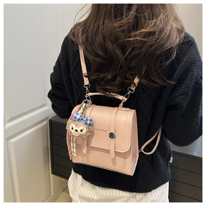 Detail of pink vintage PU leather backpack with decorative straps and metallic buckle clasp