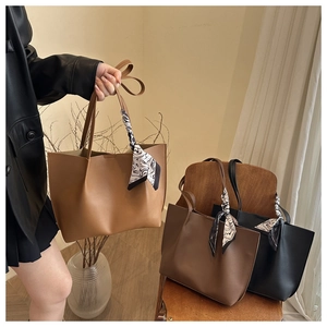 Three large matte leather tote bags in tan, brown, and black with silk scarf detail