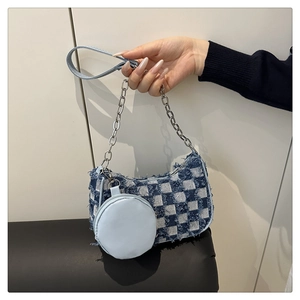 Dettaglio borsa in denim a scacchi blu con catena d'argento e portamonete rotondo