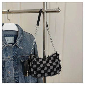 Dettaglio borsa hobo in tweed a scacchi con bordi sfrangiati e mini portamonete tondo