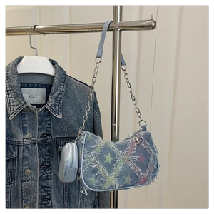 Dettaglio borsa sottobraccio in denim con motivi a stelle, frange e mini portamonete