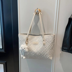 White quilted tote bag with soft diamond texture and plush cloud keychain accessory